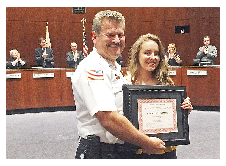 Naperville Fire Chief Mark Puknaitis presents a Fire Chief’s Award to resident Christine Sentman