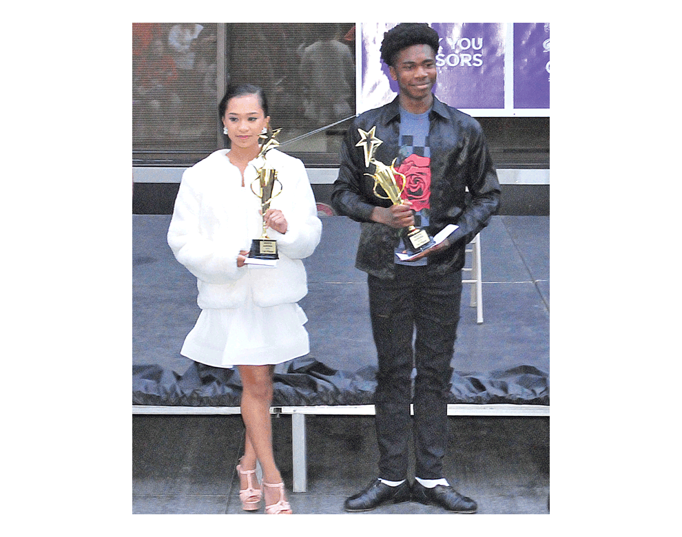 First place winners hold their trophies at the Roots Aurora talent show Friday on Water Street Mall. Kayla, left, was first place in vocalist, and Antonio was first place in dance.