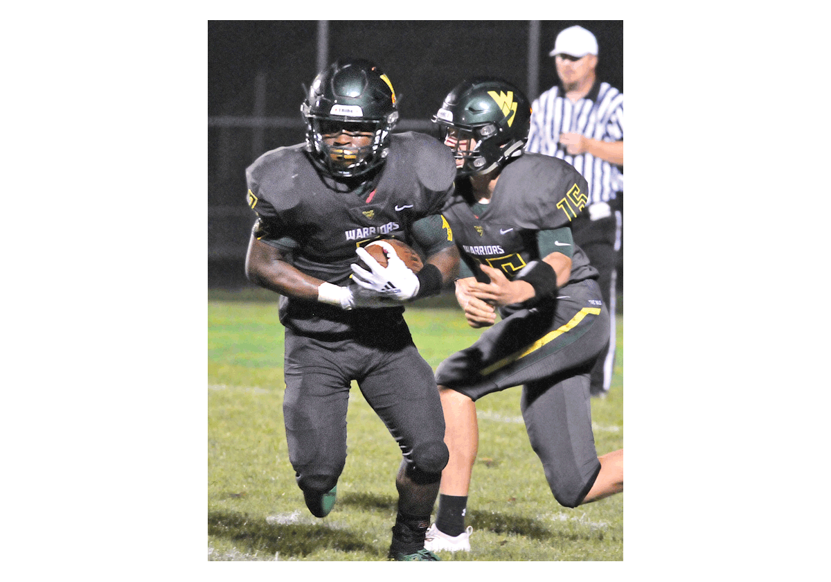 Bryce Logan of Waubonsie Valley High School looks for running room after taking a handoff from quarterback Jack Drow