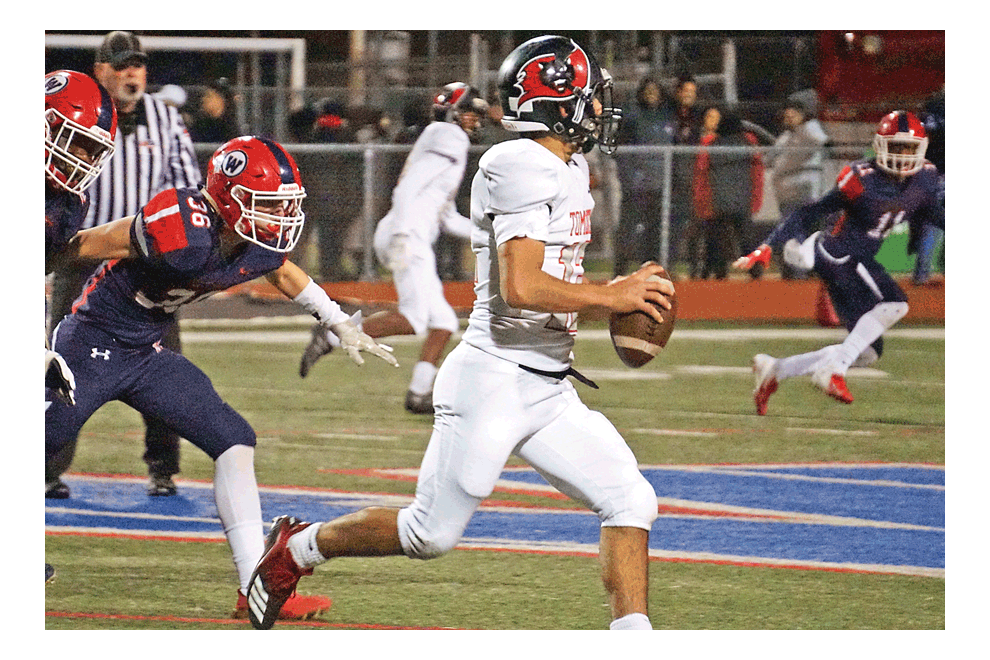 East Aurora High School quarterback Orlando Garcia looks down the field for a receiver in Friday’s East-West game