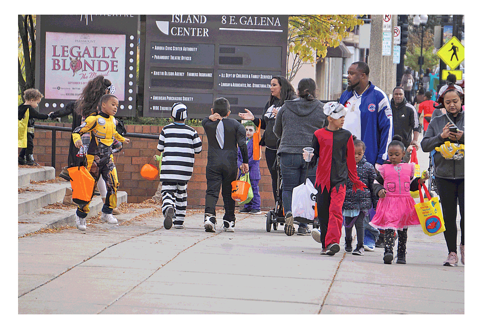 A clear day Saturday afternoon provided a backdrop for families to be engaged in trick-or-treat activities in downtown Aurora. Merchants were ready with gifts. Some of the youngsters and families started early. The event was sponsored by Aurora Downtown. Carter Crane/The Voice