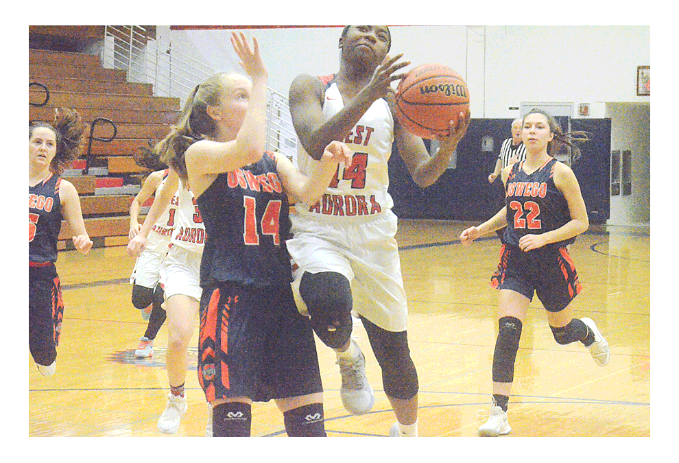 West Aurora High School guard Dajour Miles drives to the basket and is defended by Oswego's Danielle Dorilio Friday at the Lady Warhawk Thanksgiving tournament at West Aurora. Oswego won, 66-56. Al Benson/The Voice