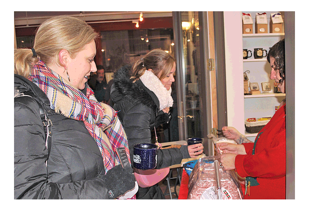 Downtown Aurora’s inaugural Cocoa Crawl Friday, Dec. 7 was a hot treat for those participating in the First Fridays event led by Aurora Downtown. At the Aurora Regional Fire Museum, Meredith Kober, left, from Aurora, and Heidi Semenek, from Oswego, receive candy canes in addition to their cocoa. Hot cocoa sampling was unlimited with $5 purchase of the blue custom Cocoa Crawl mug created by Auroran Stephanie Wheatley. All 800 mugs created were sold. Participating locations included: All Spoked Up, Aurora Art Studios, Aurora Regional Fire Museum, Branch Gardens, Endiro Coffee, PME Cake, Calla Lily Tea Room, David L. Pierce Art & History Center, Santori Public Library of Aurora, SciTech Hands On Museum, Tavern on Broadway, Tredwell Coffee, Two Brothers Roundhouse, Waubonsee Community College, Wyckwood House, and Zen Loft Wellness Center. Free Trolley service was offered to the First Fridays locations in the downtown. Jason Crane/The Voice