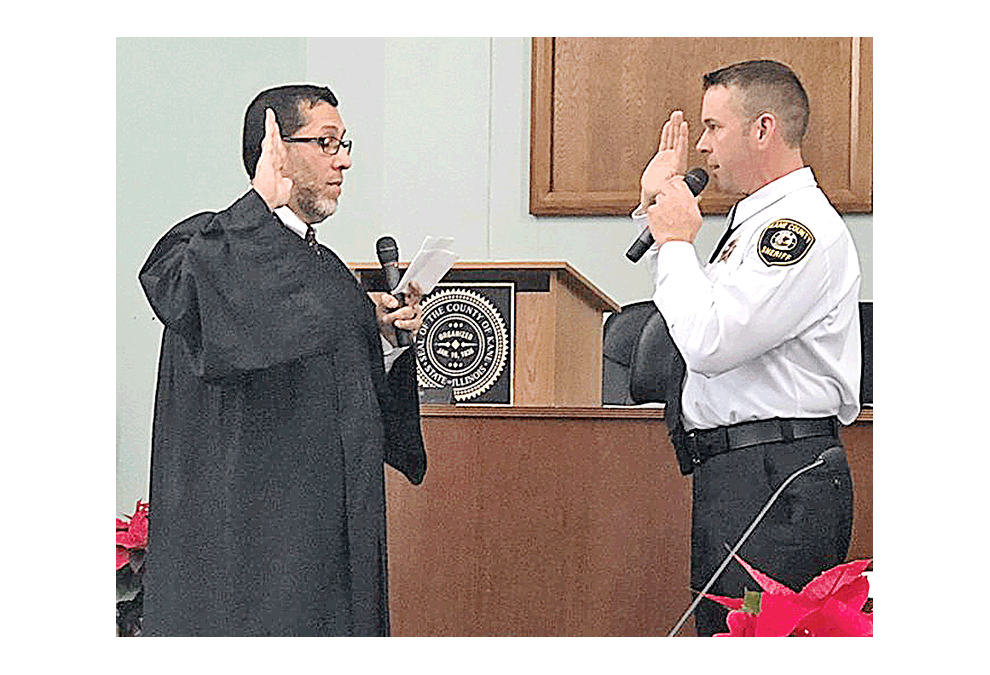 Kane County’s 16th Judicial Circuit Court Judge René Cruz, left, provides swearing in ceremony to recently-elected Sheriff Ron Hain in St. Charles Monday. Theresa Tooley Barreiro photo