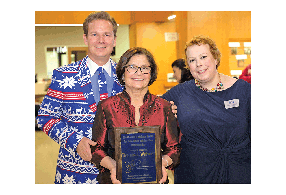 Marilyn Weisner holds a plaque presented to her husband, the Thomas J. Weisner Award for Excellence in Education Collaboration, at Saturday’s We Care Together Party and Auction at the Santori Library of Aurora. He was the first recipient. Left is John Savage, president of the Aurora Public Library Board, and Daisy Porter Reynolds, the APL executive director. Submitted photo