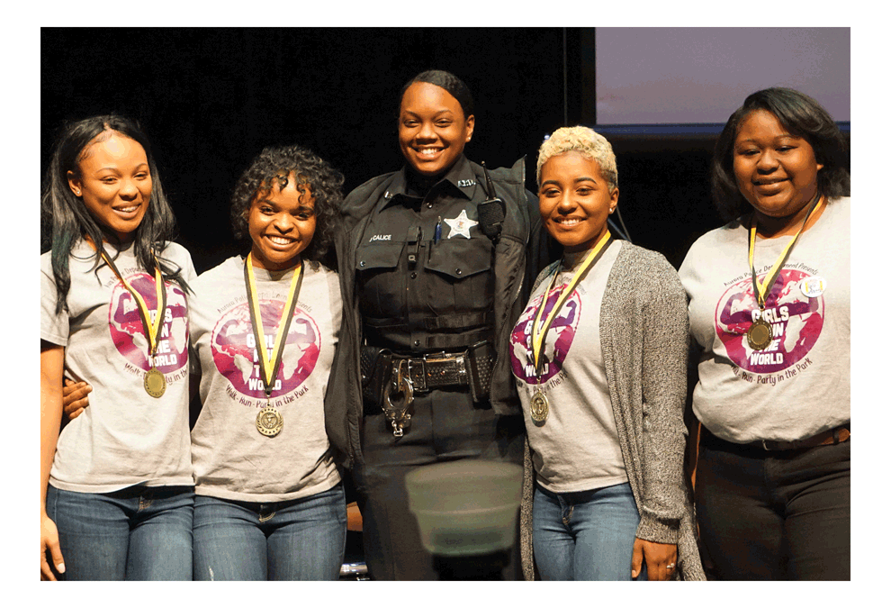 Leader of the Year Award: Aurora Police Officer Skyy Calice, middle, receives acknowledgement at the Aurora MLK commemoration Monday at East Aurora High School as the Leader of the Year recipient from the Aurora African American Heritage Advisory Board. She poses with some of the teens she has been serving as a mentor for going above and beyond to inspire and make an impact on young ladies in the Aurora community. Skyy founded her mentoring programs for young women and has inspired others to do the same in Aurora. Her first Girls on the Run 5K brought out hundred of participants and raised thousands of dollars for youth mentoring in Aurora. Jason Crane/The Voice