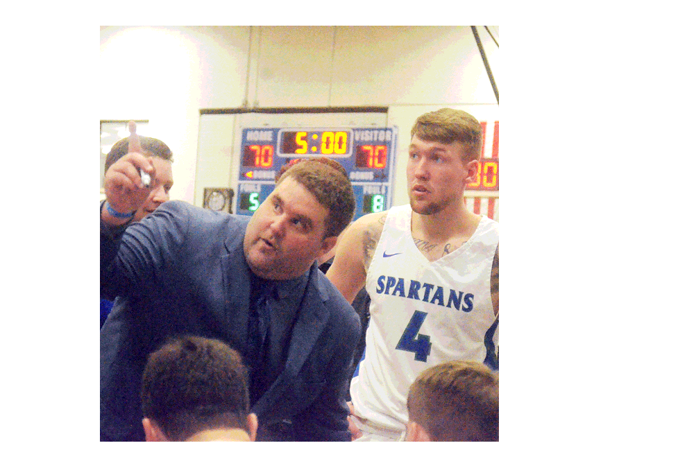 Aurora University head coach Lance Robinson, center, huddles with his men’s Spartans basketball team prior to an overtime session Monday against visiting Benedictine University at Lancaster Court in Aurora. Aurora won, 78-73. Al Benson/The Voice