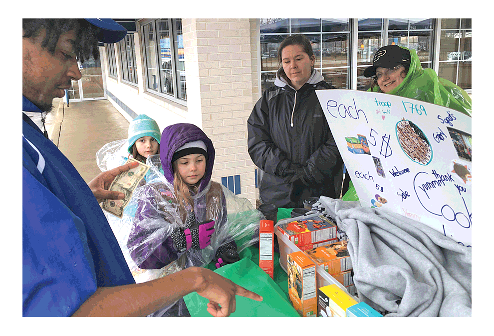 Montgomery Girl Scout Troop 1769 makes cookie sales at Culver’s in Oswego Saturday. The season is here for Nationwide Girl Scout cookies. Latrell Austin, left, decides which cookies to purchase. Jason Crane/The Voice