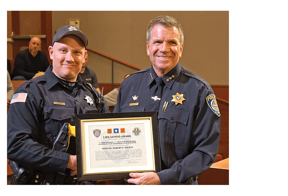 Montgomery Police Officer Bob Kaleta, left, receives the Life saving Award from Montgomery Police Chief Phil Smith at the Village Board meeting in Montgomery Monday. Kaleta performed CPR to save the life of an unconscious man January 19. Jason Crane/The Voice