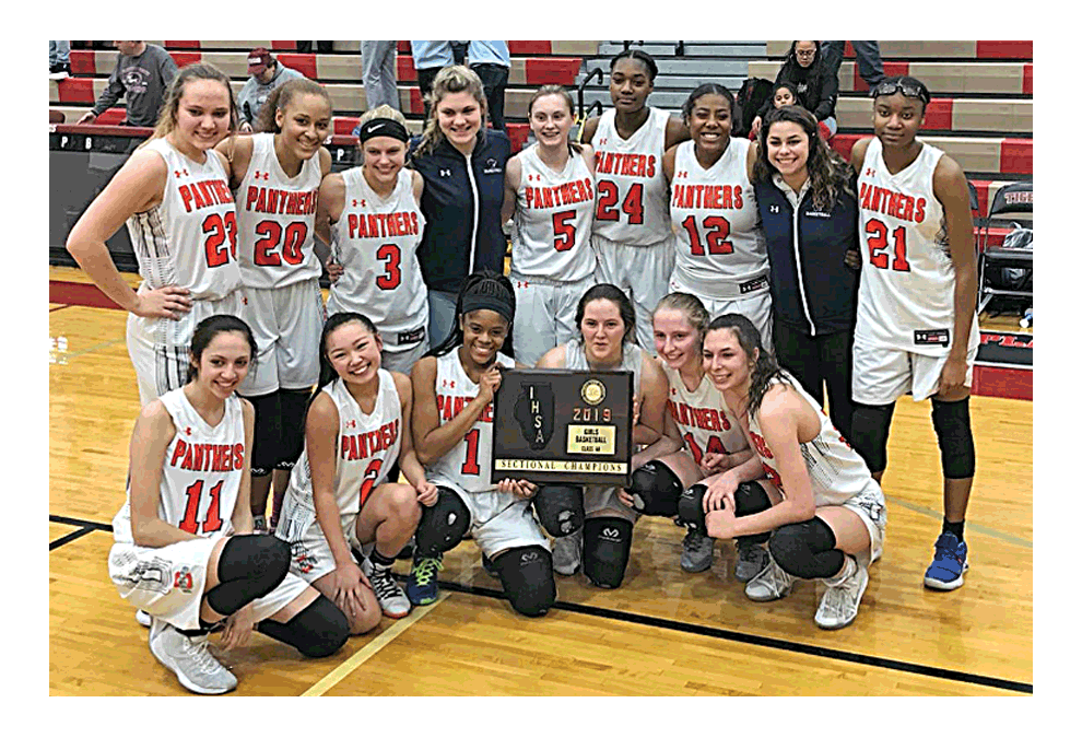 Oswego High School girls basketball team members pose for photos February 21 following its 48-28 victory against Joliet Central in the Sectional Tournament championship game