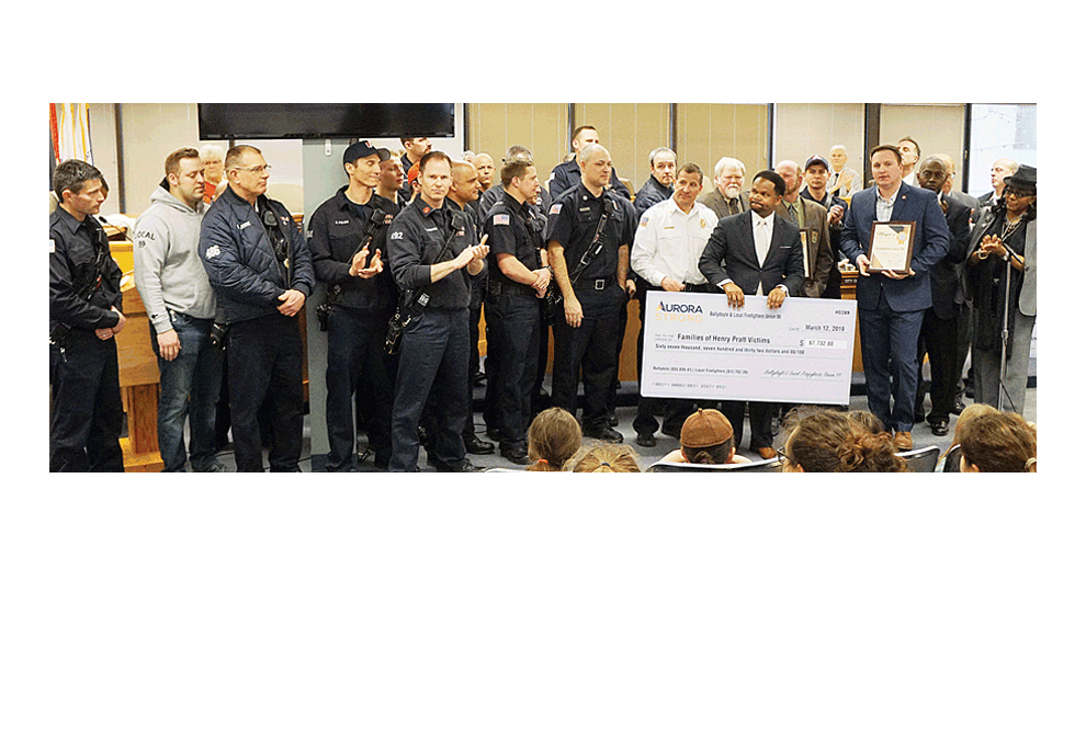 Mayor Richard Irvin of Aurora holds a check for $67,732.80 at Tuesday’s City Council meeting, which was raised at a March 3 fundraiser at a packed Ballydoyle Pub and combined with Firefighters Union Local 99 for the families of the tragic shooting February 15 at the Henry Pratt warehouse in Aurora. Jason Crane/The Voice