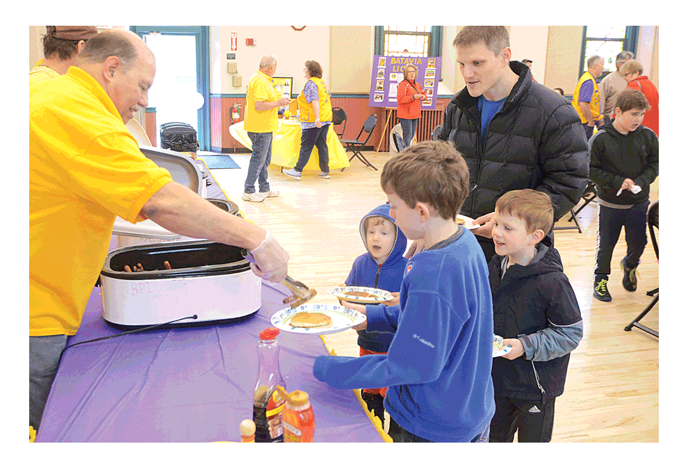 Batavia resident Rick Goebel, left, serves sausages at Batavia Lions Club’s 42nd annual pancake breakfast fundraiser Saturday at Eastside Community Center in Batavia. Goebel is a 32-year Batavia Lion. Elburn Lions Club member Jim Litsett provided free vision screenings for visitors, age six months to adults. Breakfast proceeds go to Batavia Lions’ vision care efforts for youth and adults. Al Benson/The Voice