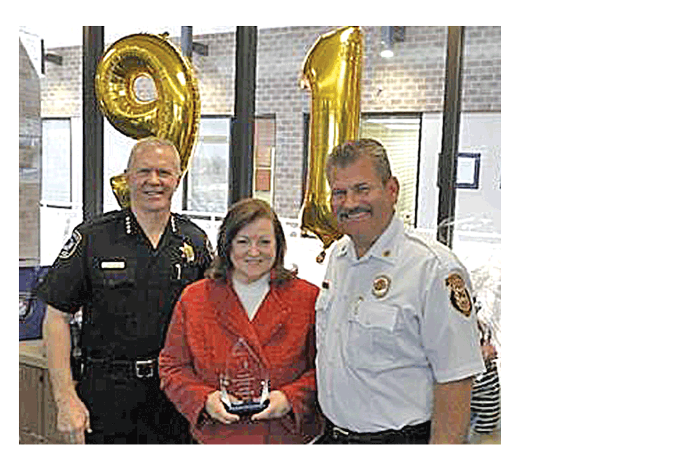 Naperville Police Chief Robert Marshall, left, and Fire Chief Mark Puknaitis, right, present Emergency Communications manager Kalah Considine, center, with Naperville’s 2019 Telecommunicator of the Year Award.