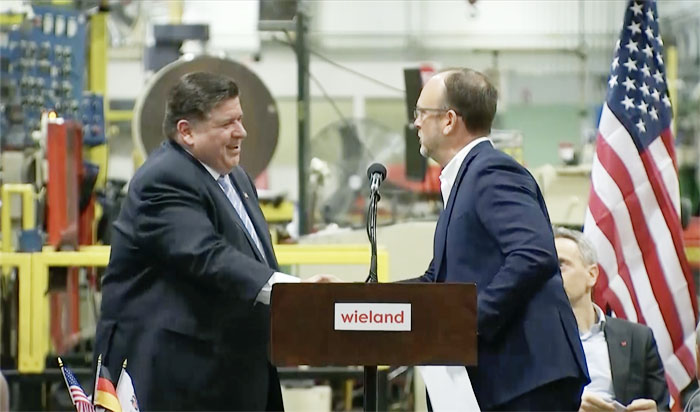 Gov. JB Pritzker shakes hands with Greg Keown, president of Wieland Rolled Products North America