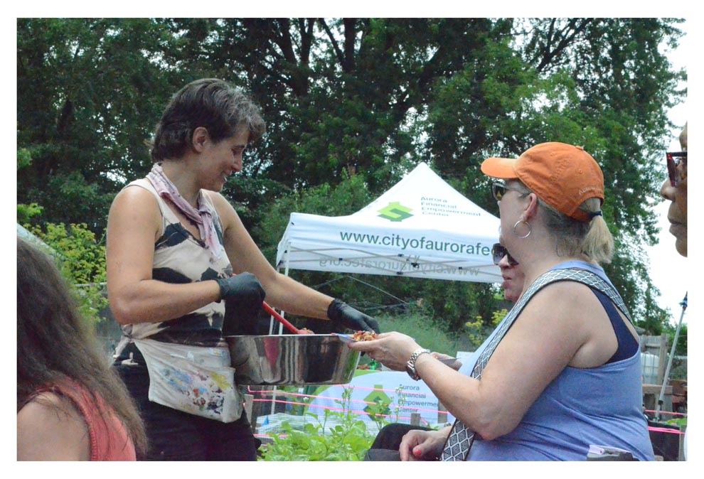 Rebekah Axtell, left, communications specialist for Marie Wilkinson Food Pantry, offers samples of local chef and dietician student Julie Rudnicki's "Cowboy Caviar" summer bean salad at Marie's Garden Saturday. 
