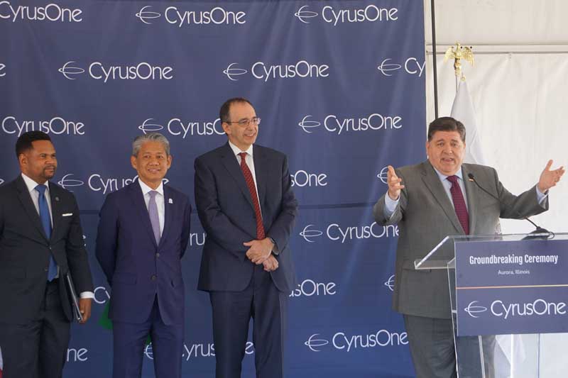 Mayor of Aurora, Richard Irvin, Gil Quiniones, and Eric Schwartz, the CEO of CyrusOne listen to remarks by Illinois Governor JB Pritzker Wednesday, Oct. 2 in Aurora.